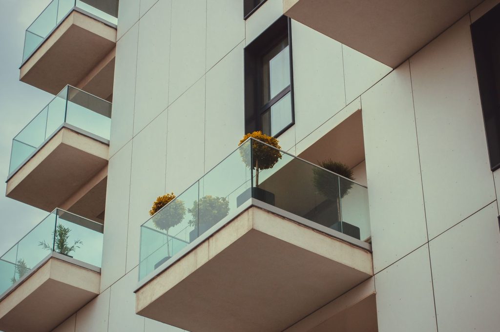 Modern apartmanház üveg erkélyekkel, növényekkel